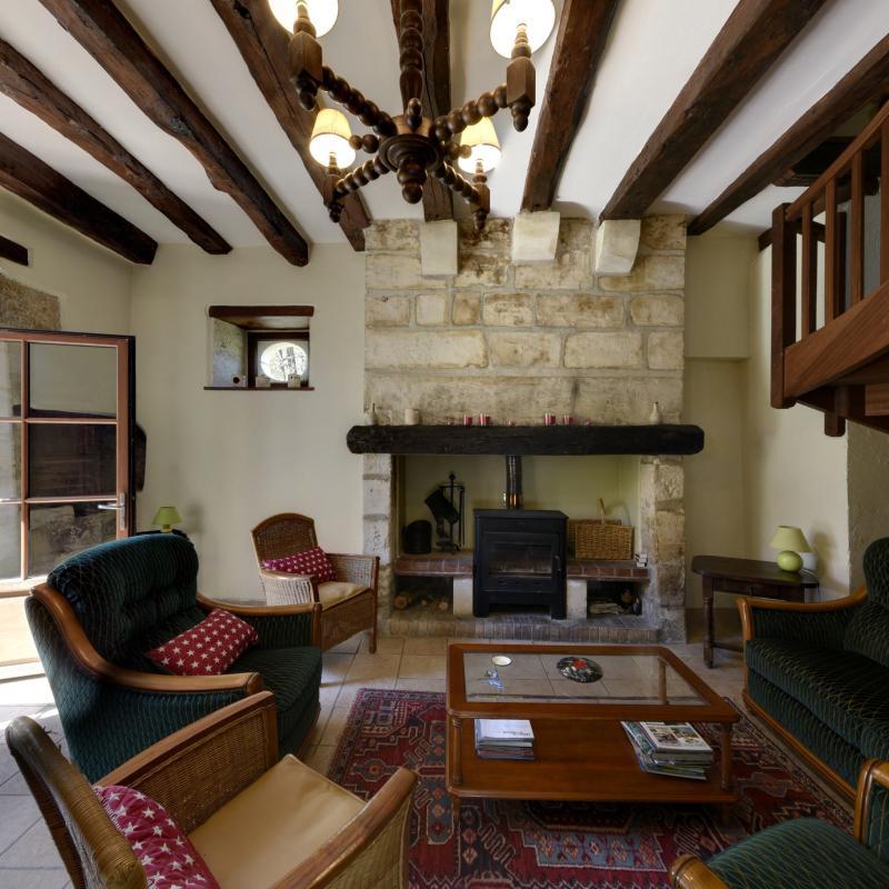 Le salon en pierre de taille, est frais l'été, et cosy en hivers avec sa cheminée, son poêle et sa télévision.